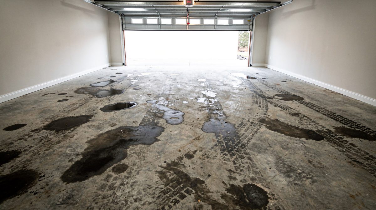 Oil-stained concrete garage floor before coating in Beaumont, TX
